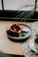 Breakfast with toast, coffee and berries on the table in cafe photo
