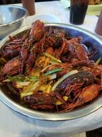 Boiled crayfish with onions and lemon in a metal bowl photo