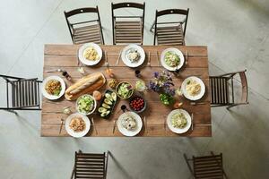 Top view of wooden table with different salads and sandwiches in cafe, above view photo