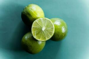Lime slices on green background. Top view. Copy space. photo