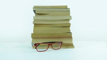 Stack of books and reading glasses on white background. Education concept. photo