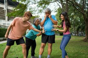 Healthy family group instructors workout in fresh air, and they rest and stand together after morning exercises in park. Outdoor activities, healthy lifestyle, strong bodies, fit figures, health care. photo