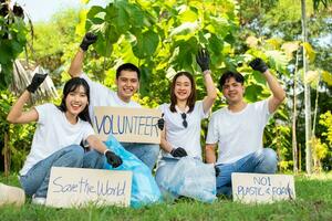 contento joven asiático estudiantes diverso voluntarios sostener un Campaña firmar para limpieza en el parque, el concepto de ambiental conservación en mundo ambiente día, reciclaje, caridad para sostenibilidad. foto