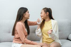 dos mujer hablando acerca de problemas a hogar. asiático mujer abrazo a calma su triste mejor amigos desde sensación abajo. hembra amigos secundario cada otro. problemas, amistad, y cuidado concepto foto