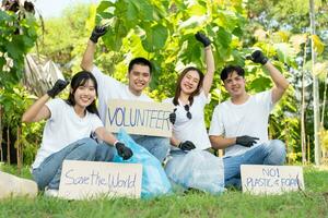 contento joven asiático estudiantes diverso voluntarios con basura pantalones limpieza zona en el parque, el concepto de ambiental conservación en mundo ambiente día, reciclaje, caridad para sostenibilidad. foto