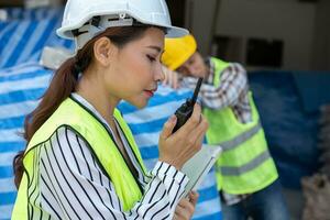 Foreman user radio to nurse for first aid Construction worker faint in construction site because Heat Stroke. Worker with safety helmet take a nap because so are tired from working in the hot sun photo