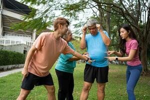 Healthy family group instructors workout in fresh air, and they rest and stand together after morning exercises in park. Outdoor activities, healthy lifestyle, strong bodies, fit figures, health care. photo