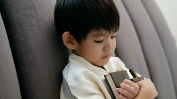 liten asiatisk pojke ber innehav en korsa och en religiös bok, kristen begrepp, 4k upplösning. video