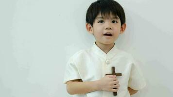 Little Asian boy praying with holding the cross, Christian concept video