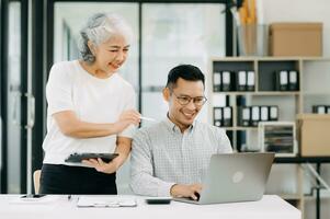 Portrait of success Asian business people working together in office. Couple teamwork startup concept photo