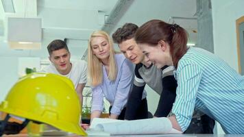 grupo de joven ingenieros que se discute arquitectónico planos video