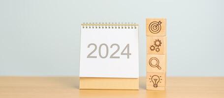 2024 año calendario con madera negocio bloquear, meta, estrategia, objetivo, resolución, misión, acción, crecimiento, trabajo en equipo, plan, idea y nuevo año comienzo concepto foto