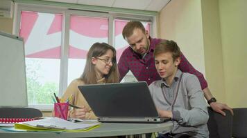 masculino professor ajudando dele Adolescência alunos com uma projeto às escola video