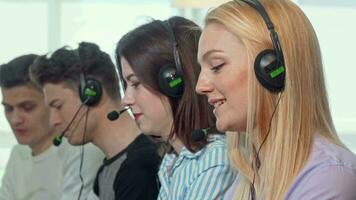 Charming female call center operator smiling to the camera while working video