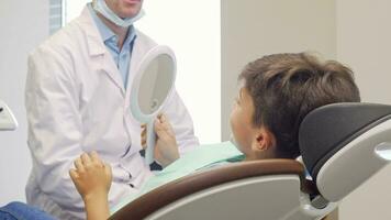 Little boy smiling to the camera after checking out his healthy teeth in the mirror video