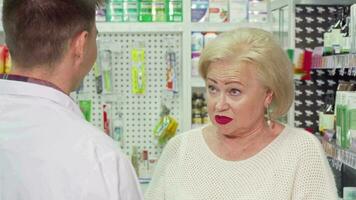 Senior woman with sore throat asking pharmacist for medicine video