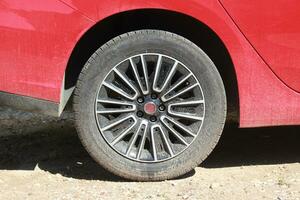 a red car with a tire on it photo