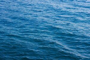 generic boundless sea water surface, only blue water at day time with mild ripple vawes photo