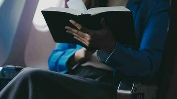 geslaagd vrouw boek editor lezing literatuur gedurende tijd in vliegtuig voordat bedrijf vergadering met auteur, zelfverzekerd formeel gekleed vrouw genieten van Internationale vlucht en vrije tijd voor roman video