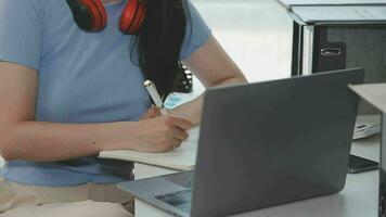 Charming Young asian businesswoman sitting on laptop computer in the office, making report calculating balance Internal Revenue Service checking document. video