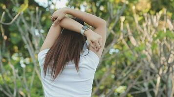 Young woman stretching before running while looking for beautiful landscape on roadside. Sports and Recreation video