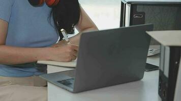 encantadora joven mujer de negocios asiática sentada en una computadora portátil en la oficina, haciendo un informe que calcula el documento de verificación del servicio de ingresos internos del saldo. video