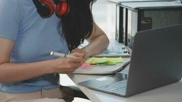 Charming Young asian businesswoman sitting on laptop computer in the office, making report calculating balance Internal Revenue Service checking document. video