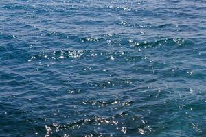 generic boundless sea water surface, only blue water at day time with mild ripple vawes photo