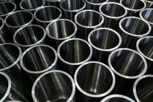 dark industrial background with cnc machined shiny steel pipes - selective focus and lens blur tech photo