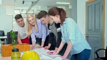 Jeune architectes travail ensemble sur une plan à le Bureau video