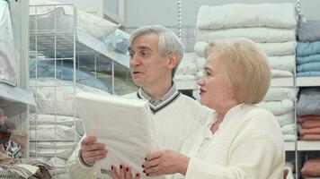 Happy elderly couple laughing, talking while shopping for home goods video