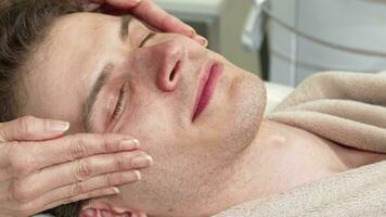 Cropped shot of a happy man enjoying head and face massage at spa center video