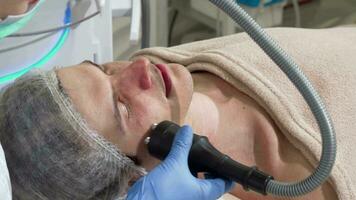 Handsome man getting rf-lifting treatment by cosmetologist video