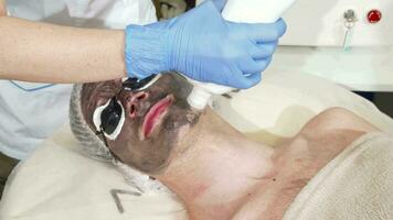 Cosmetologist doing facial carbon peeling for male client video