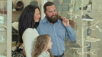 Lovely family looking at the display of clothing store at shopping mall video