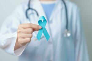 Blue November Prostate Cancer Awareness month, Doctor with Blue Ribbon in hospital for support people life and illness. Healthcare, International men, Father, Diabetes and World cancer day photo