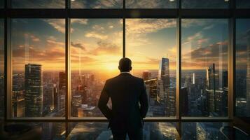 confident businessman watching city sunset through window photo