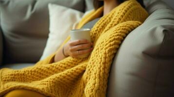 cozy wool blanket on sofa hand holding pillow for relaxation photo