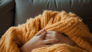 cozy wool blanket on sofa hand holding pillow for relaxation photo