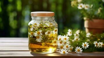 fresh chamomile flower in a glass jar on a wooden table photo