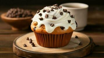 homemade chocolate chip muffin with creamy icing on wooden table photo