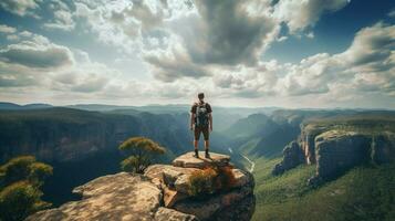 one man standing on cliff backpacking adventure photo