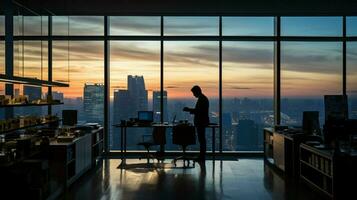 silhouette businessman working on computer in empty office photo