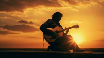 silueta de músico jugando guitarra a puesta de sol foto