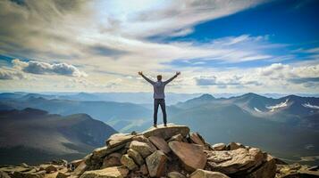 en pie triunfantemente encima rocoso montaña pico brazos aumento foto