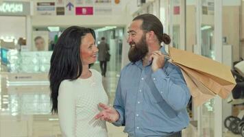 Bearded handsome man and his lovely wife looking inside shopping bags video