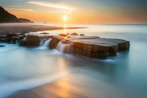 un largo exposición fotografía de un rock formación en el playa a puesta de sol. generado por ai foto