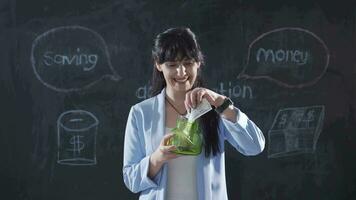 The woman who writes Savings on the board looks cheerfully at the camera. video