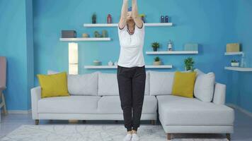 Frau ausüben beim Zuhause Dehnen ihr Waffen. gesund Leben Fitness. video