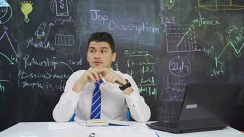 Businessman writes Job description on blackboard and talks tutorial. video